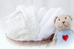 Set pieluszki dla nowonarodzonego w koszu z miłość niedźwiedzia zabawką Dziecka cl zdjęcie stock Set pieluszki dla nowonarodzonego w koszu z miłość niedźwiedzia zabawką Dziecka cl zdjęcie stock