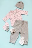 Set of pink and gray children`s clothes on a light blue background. shirt, gray trousers, socks and an elephant`s toy. royalty free stock images Set of pink and gray children`s clothes on a light blue background. shirt, gray trousers, socks and an elephant`s toy. royalty free stock images