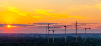 Several construction cranes on the background of colorful sunset sky stock photography Several construction cranes on the background of colorful sunset sky stock photography