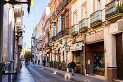 Seville, Spain, January 11, 2019 - a street with traditional facades of houses with twisted wrought-iron balconies and an alley of royalty free stock photos Seville, Spain, January 11, 2019 - a street with traditional facades of houses with twisted wrought-iron balconies and an alley of royalty free stock photos