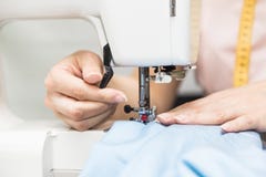 Sewing workshop. Seamstress at work. Young woman working with sewing machine. stock photo Sewing workshop. Seamstress at work. Young woman working with sewing machine. stock photo