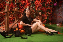Sexy And Attractive Brunette Witch In Autumn Colorful Park With Orange And Red Leaves Posing With Pumpkins Stock Images