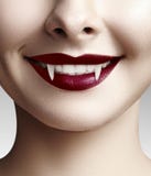 Sexy female vampire lips. Halloween background with red blood makeup lip. Masquerade look with terrible fags Royalty Free Stock Photography Sexy female vampire lips. Halloween background with red blood makeup lip. Masquerade look with terrible fags Royalty Free Stock Photography
