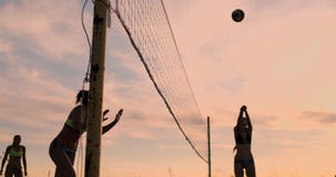 Sexy volleyball girls in bikini play on the beach in summer volleyball on the sand at sunset in slow motion. stock video footage Sexy volleyball girls in bikini play on the beach in summer volleyball on the sand at sunset in slow motion. stock video footage