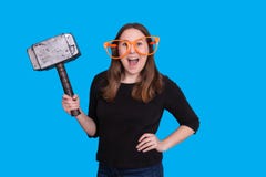 Señora joven que sostiene un apoyo de goma de la foto del martillo del mazo y un retrato anaranjado grande de la cabina de la fot foto de archivo libre de regalías Señora joven que sostiene un apoyo de goma de la foto del martillo del mazo y un retrato anaranjado grande de la cabina de la fot foto de archivo libre de regalías