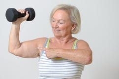 Señora mayor que lleva a cabo una pesa de gimnasia fotos de archivo libres de regalías Señora mayor que lleva a cabo una pesa de gimnasia fotos de archivo libres de regalías