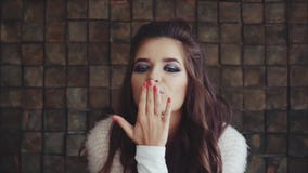 Sguardo castana della donna graziosa alla macchina fotografica e soffiare un bacio stock footage Sguardo castana della donna graziosa alla macchina fotografica e soffiare un bacio stock footage