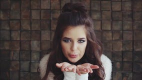 Sguardo castana della giovane bella donna alla macchina fotografica e soffiare un bacio stock footage Sguardo castana della giovane bella donna alla macchina fotografica e soffiare un bacio stock footage