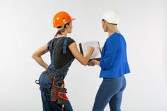 Sguardo di architettura di due donne nel piano e nella discussione dei problemi di costruzione sul fondo bianco immagine stock libera da diritti Sguardo di architettura di due donne nel piano e nella discussione dei problemi di costruzione sul fondo bianco immagine stock libera da diritti