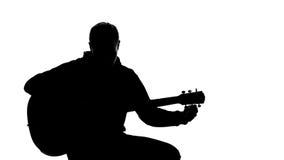Shadow of young musician tuning up guitar, professional writing song, hobby stock images Shadow of young musician tuning up guitar, professional writing song, hobby stock images