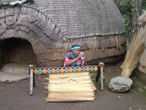 Shakaland, SURÁFRICA - CIRCA noviembre de 2011: Las mujeres no identificadas del Zulú tejen una estera imagen de archivo Shakaland, SURÁFRICA - CIRCA noviembre de 2011: Las mujeres no identificadas del Zulú tejen una estera imagen de archivo