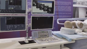 SHANGHAI - 28 DE JUNHO DE 2018: Operação médica do robô que envolve o robô que executa a cirurgia na laparoscopia humana modelo d foto de stock SHANGHAI - 28 DE JUNHO DE 2018: Operação médica do robô que envolve o robô que executa a cirurgia na laparoscopia humana modelo d foto de stock