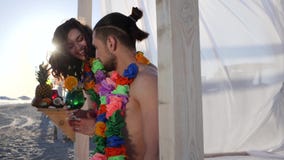 Shapely girl brought for man cocktail on beach, summer vacation young couple in Hawaii, girl comes to guy with an stock video footage Shapely girl brought for man cocktail on beach, summer vacation young couple in Hawaii, girl comes to guy with an stock video footage