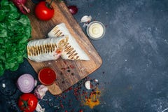 Shawarma di kebab di Doner o involucro del doner Pollo grigliato sul pane della pita del lavash con gli ortaggi freschi - pomodor fotografia stock libera da diritti Shawarma di kebab di Doner o involucro del doner Pollo grigliato sul pane della pita del lavash con gli ortaggi freschi - pomodor fotografia stock libera da diritti