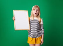 Shocked pupil showing blank board against green background Royalty Free Stock Photos Shocked pupil showing blank board against green background Royalty Free Stock Photos