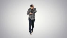 Shoked young man holding phone and reading message when walking on gradient background. royalty free stock images Shoked young man holding phone and reading message when walking on gradient background. royalty free stock images