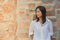 Shoot photo Asian woman portrait wear white shirt and looking sideways with red brick background. Shoot photo Asian woman portrait wear white shirt and looking Stock Photography Shoot photo Asian woman portrait wear white shirt and looking sideways with red brick background. Shoot photo Asian woman portrait wear white shirt and looking Stock Photography