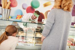 Shopkeeper in confectionery serves girl with ice cream stock photos Shopkeeper in confectionery serves girl with ice cream stock photos