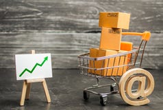 Shopping cart filled with boxes, email symbol and stand with green up arrow. shopping online. Growth rate of Internet sales