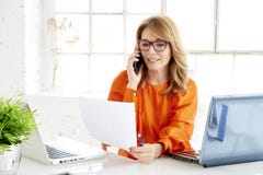 Shot of attractive mature businesswoman using her mobile phone and talking with her client royalty free stock photo Shot of attractive mature businesswoman using her mobile phone and talking with her client royalty free stock photo