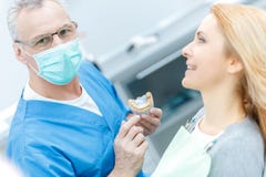 Showing jaws model to patient in dental clinic stock photo Showing jaws model to patient in dental clinic stock photo