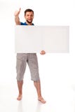 A guy with a beard posing with a white sign. Can be used to place advertising, logo, and other. Dressed in a blue T-shirt and grey royalty free stock image A guy with a beard posing with a white sign. Can be used to place advertising, logo, and other. Dressed in a blue T-shirt and grey royalty free stock image