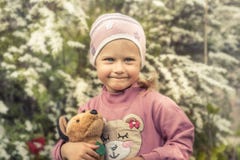 Shy cute child girl with toy smiling portrait soft flowers background concept happy childhood lifestyle royalty free stock images Shy cute child girl with toy smiling portrait soft flowers background concept happy childhood lifestyle royalty free stock images