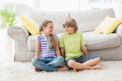 Siblings looking at each other while sitting in liviung room Stock Images Siblings looking at each other while sitting in liviung room Stock Images