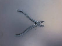 Side steel metal cutting nippers on gray and blue background stock photos Side steel metal cutting nippers on gray and blue background stock photos