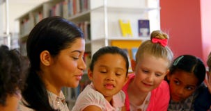 Asian female teacher teaching schoolkids in school library 4k stock video footage Asian female teacher teaching schoolkids in school library 4k stock video footage