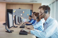 Side view of business people working at call center Stock Images Side view of business people working at call center Stock Images