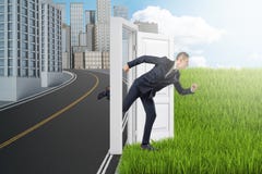 Side view of businessman running from modern city to green field through door standing alone between them with no wall. stock image Side view of businessman running from modern city to green field through door standing alone between them with no wall. stock image