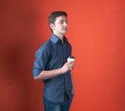 Side view of handsome young man with hand in pocket looking away and holding coffee in paper cup stock images Side view of handsome young man with hand in pocket looking away and holding coffee in paper cup stock images