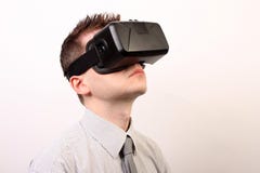 Side view of a man wearing a VR Virtual reality Oculus Rift 3D headset, looking upwards in a formal shirt and tie Royalty Free Stock Photos Side view of a man wearing a VR Virtual reality Oculus Rift 3D headset, looking upwards in a formal shirt and tie Royalty Free Stock Photos