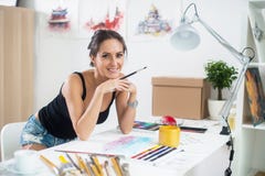 Side view portrait of a happy artist at the workplace. Young woman with paintbrush royalty free stock photo Side view portrait of a happy artist at the workplace. Young woman with paintbrush royalty free stock photo