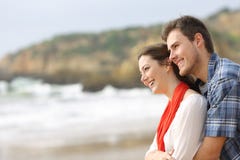 Happy couple hugging and looking at horizon on the beach stock image Happy couple hugging and looking at horizon on the beach stock image