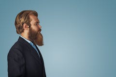 Side view portrait of serious bearded man in black suit, blue shirt stock photography Side view portrait of serious bearded man in black suit, blue shirt stock photography
