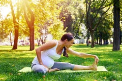 Pregnant woman doing relaxing yoga workout in park Royalty Free Stock Images Pregnant woman doing relaxing yoga workout in park Royalty Free Stock Images