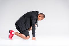 side view of young african american sportsman in hoodie kneeling stock image side view of young african american sportsman in hoodie kneeling stock image