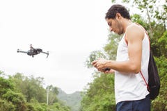 Side view of a young boy learning to fly a drone in outdoors stock photo Side view of a young boy learning to fly a drone in outdoors stock photo
