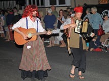 SIDMOUTH, DEVON, ENGLAND - AUGUST 10TH 2012: Two performers in fancy dress play a guitar and an accordian in the night time royalty free stock images SIDMOUTH, DEVON, ENGLAND - AUGUST 10TH 2012: Two performers in fancy dress play a guitar and an accordian in the night time royalty free stock images