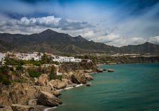 Sie sahen die spanische Gruppe der Küste A von weißen Häusern auf den Klippen durch das Meer mit den Bergen im Hintergrund lizenzfreie stockbilder Sie sahen die spanische Gruppe der Küste A von weißen Häusern auf den Klippen durch das Meer mit den Bergen im Hintergrund lizenzfreie stockbilder
