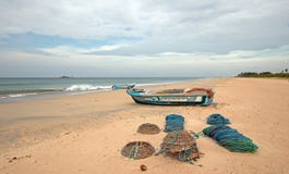 Sieci, oklepowie, kosze i arkany obok łodzi rybackiej na Nilaveli, wyrzucać na brzeg w Trincomalee Sri Lanka obrazy stock Sieci, oklepowie, kosze i arkany obok łodzi rybackiej na Nilaveli, wyrzucać na brzeg w Trincomalee Sri Lanka obrazy stock