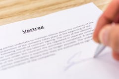 Signing of a contract with the German word for contract in the title royalty free stock photo Signing of a contract with the German word for contract in the title royalty free stock photo