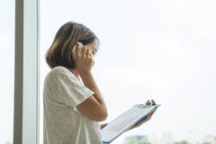 Signora dell'ufficio fa una telefonata in ufficio fotografia stock Signora dell'ufficio fa una telefonata in ufficio fotografia stock