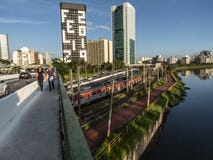 Sikt av byggnader, CPTM-drevet, trafik av medel och floden i marginell Pinheiros flodaveny arkivbilder Sikt av byggnader, CPTM-drevet, trafik av medel och floden i marginell Pinheiros flodaveny arkivbilder