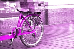 Sikt av en ljus rosa cykel med ett korganseende på trägolvet utanför royaltyfri foto Sikt av en ljus rosa cykel med ett korganseende på trägolvet utanför royaltyfri foto