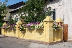 Sikt av ett tegelstenhus med ett staket och blommor fotografering för bildbyråer Sikt av ett tegelstenhus med ett staket och blommor fotografering för bildbyråer
