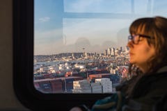 Sikter av den Seattle fjärden och viktiga byggnader på solnedgången från fönstret av en offentlig buss som en ung kvinna vil arkivfoto Sikter av den Seattle fjärden och viktiga byggnader på solnedgången från fönstret av en offentlig buss som en ung kvinna vil arkivfoto