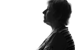 Silhouet van een oude droevige vrouw royalty-vrije stock afbeeldingen Silhouet van een oude droevige vrouw royalty-vrije stock afbeeldingen